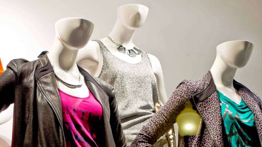 Three female mannequins wearing designer clothes.